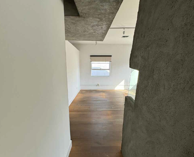 Daylit room in Suite 154 1/2 with exposed concrete ceiling and track lighting