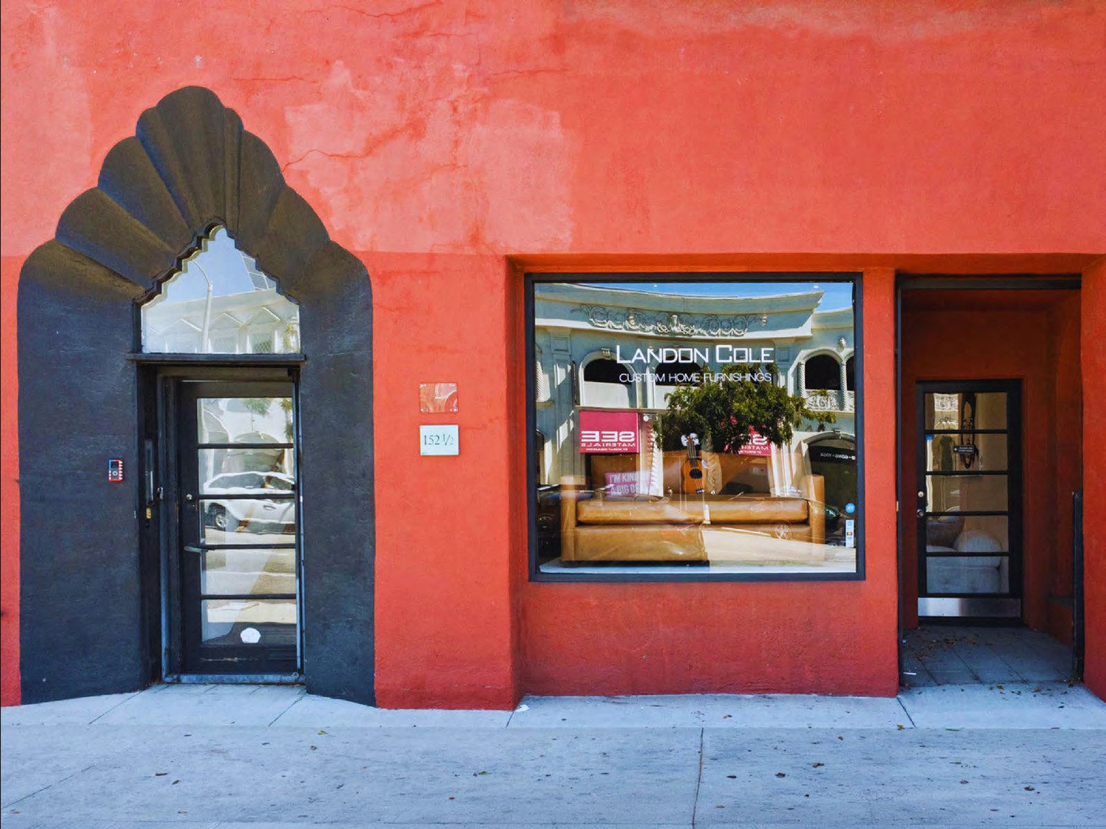 Arched black entry and display window of the orange Archway Building storefront